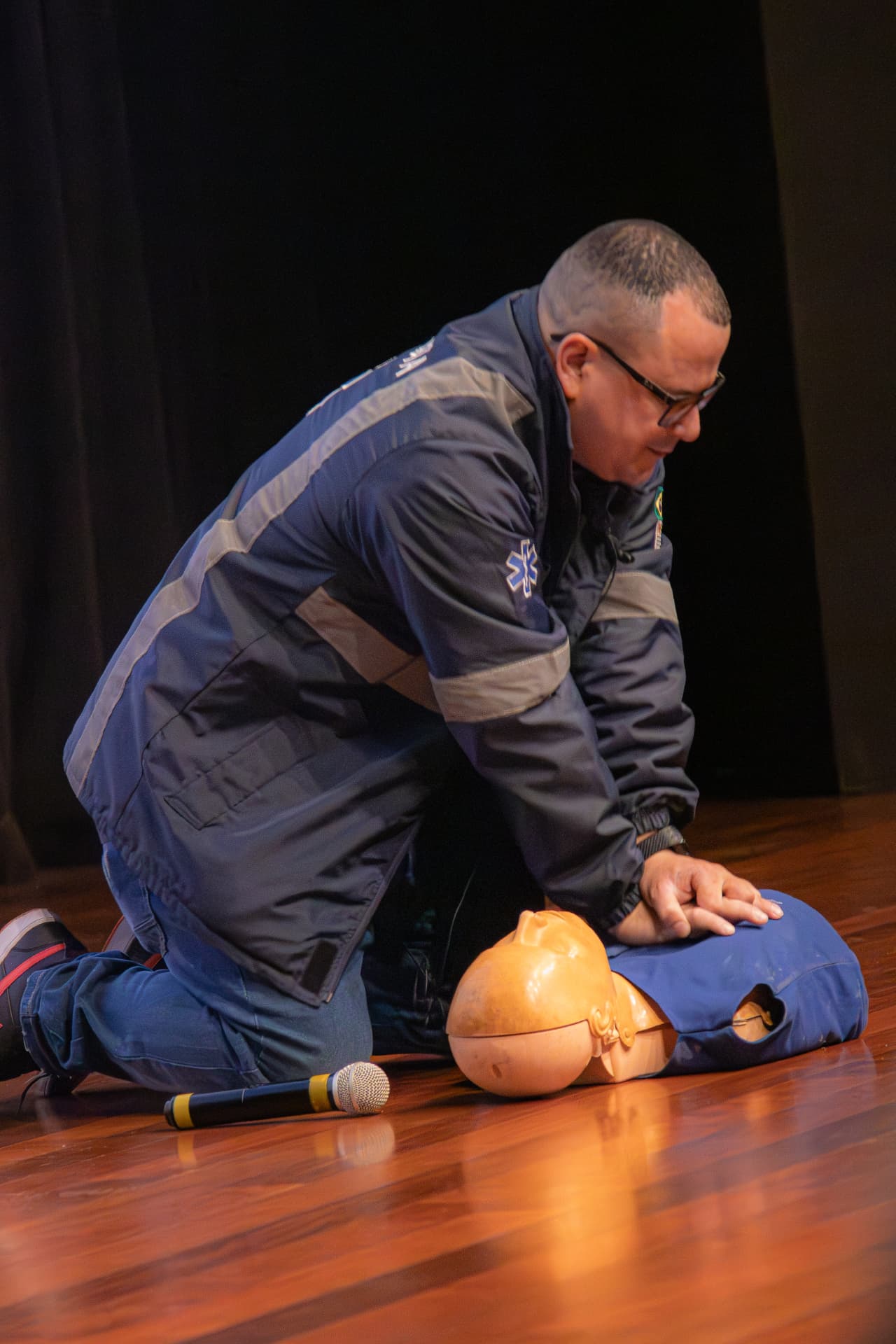 Instrutor demonstrando massagem cardíaca em manequim de treinamento