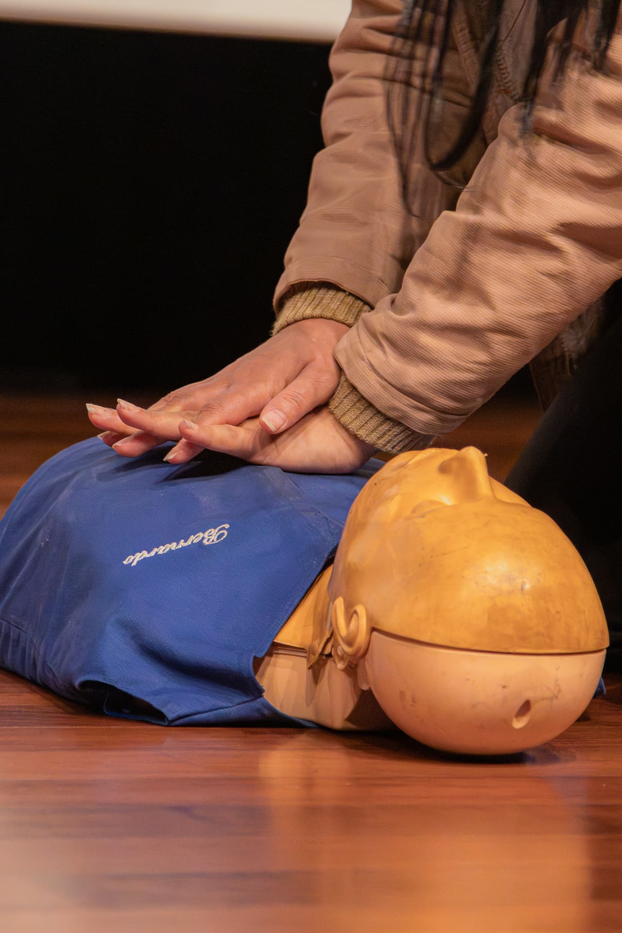 Participante praticando massagem cardíaca em manequim