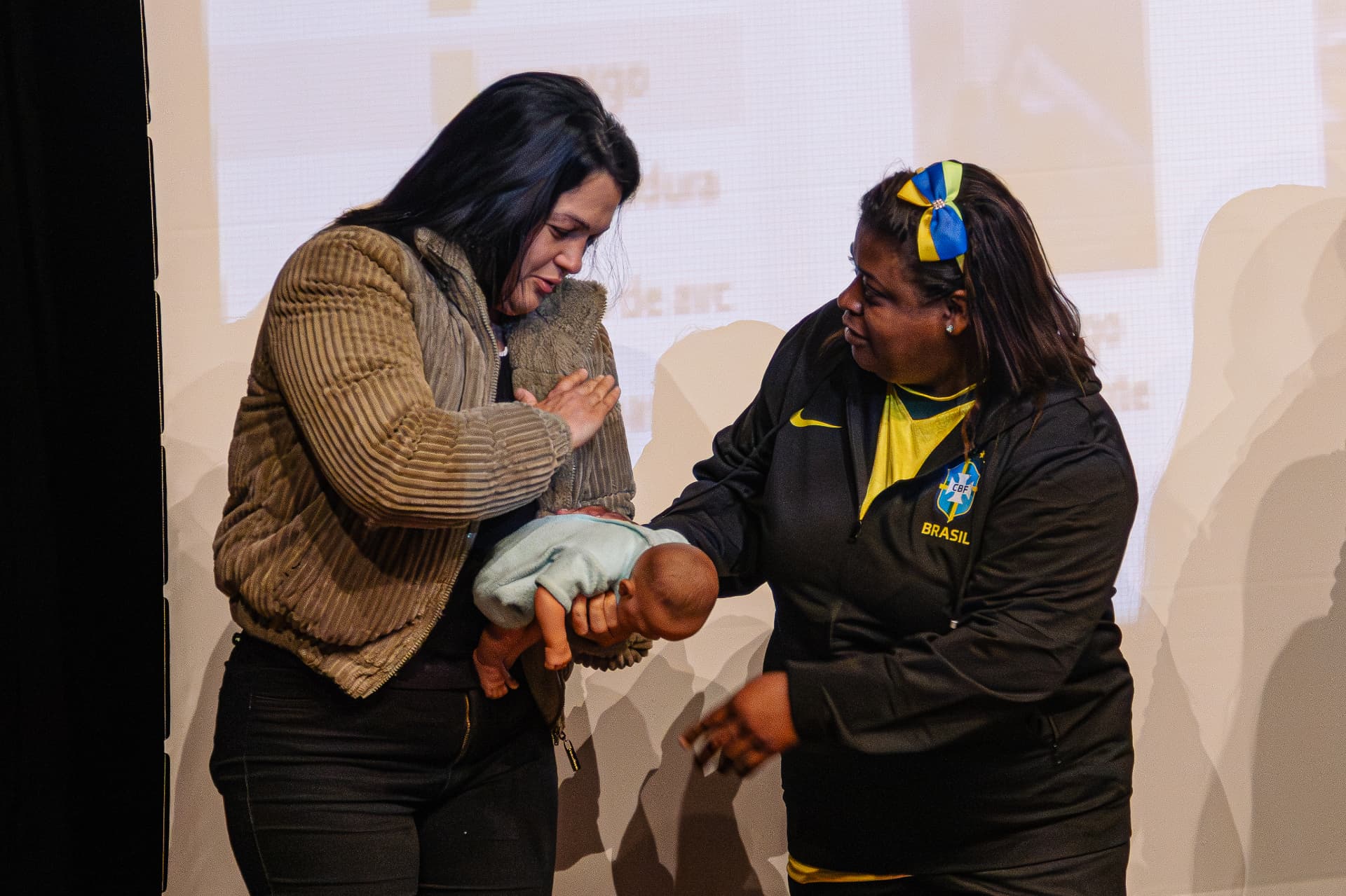 Participantes praticando primeiros socorros em bebê